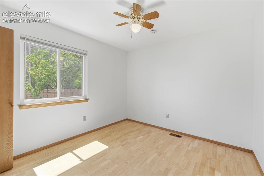 Image 14 of 29: Room featuring wood-finish flooring, a window with natural wood trim, and a