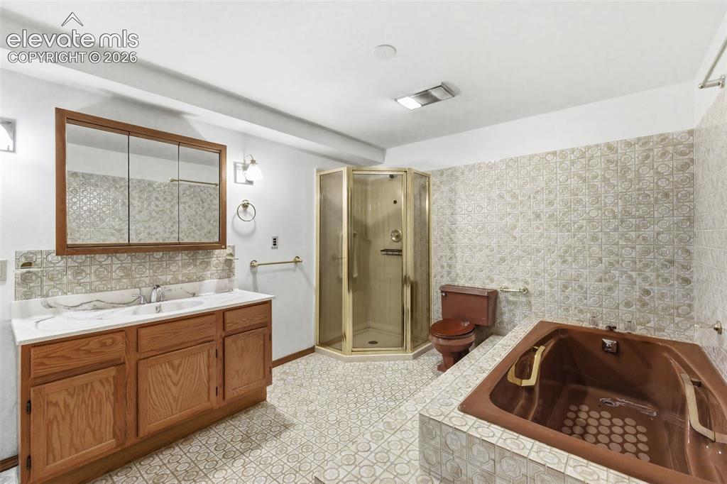 Image 21 of 29: Dual-sink vanity with wood-finish cabinetry and a framed medicine cabinet, 