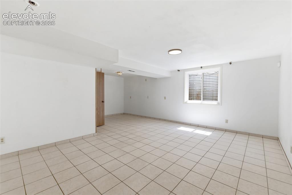 Image 22 of 29: Spacious room featuring light-toned tile flooring, white walls, a single wi