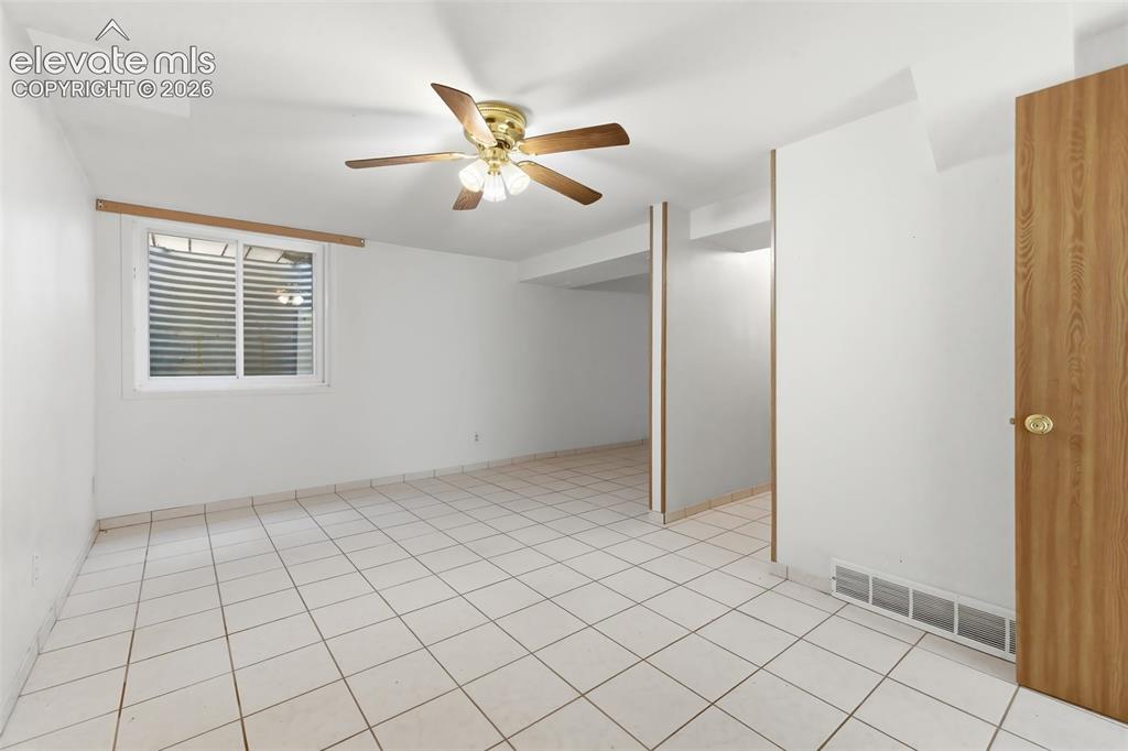 Image 24 of 29: Spacious interior featuring ceramic tile flooring, a functional window with