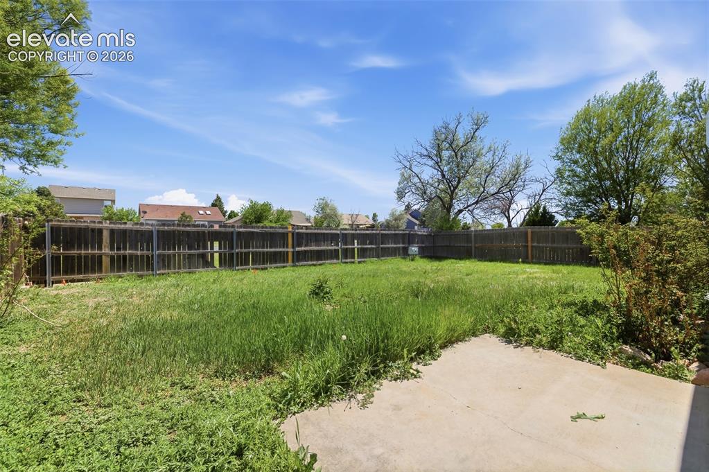 Image 25 of 29: Expansive backyard with a concrete patio