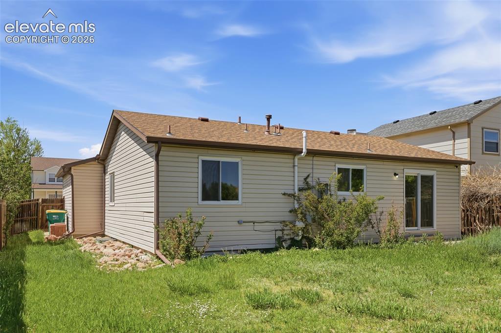 Image 28 of 29: Siding exterior with a brown shingle roof and a sliding glass door