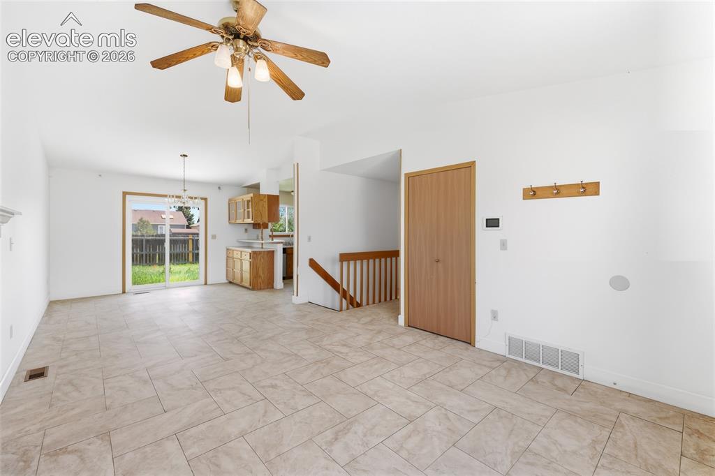 Image 4 of 29: Open-concept living space featuring neutral tile flooring, a ceiling fan wi