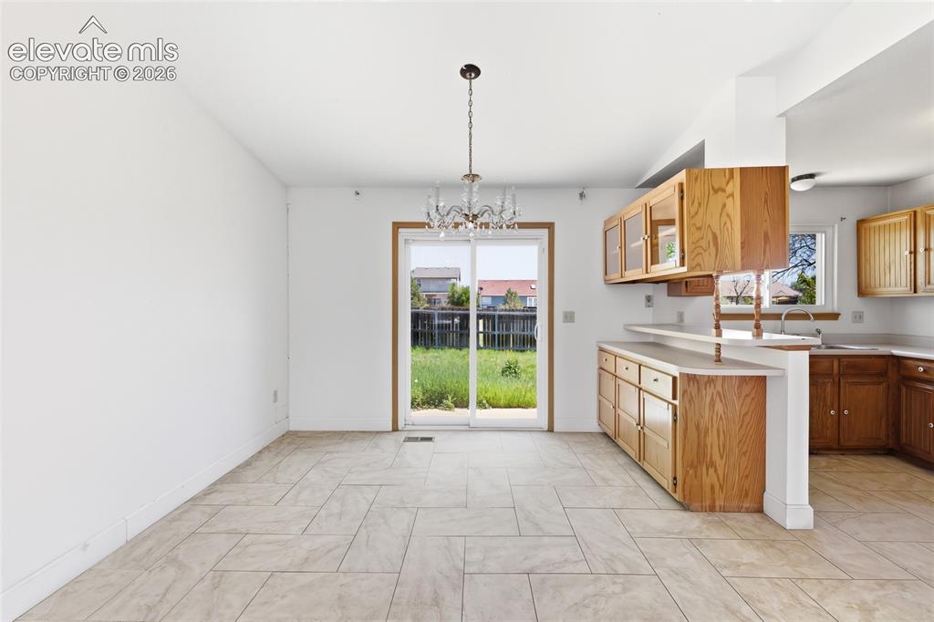 Image 5 of 29: Open-concept living space with light-toned tile flooring throughout