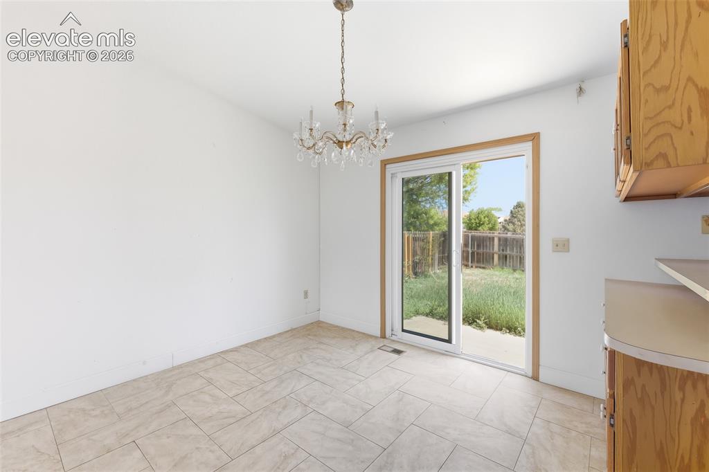 Image 8 of 29: Bright interior space featuring a crystal chandelier, neutral-toned tile fl