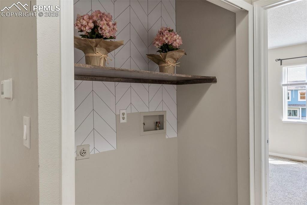 Image 12 of 24: Laundry room with hookup for a washing machine, carpet flooring, and a text