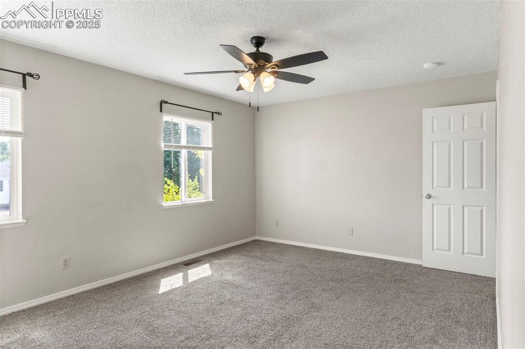 Image 14 of 24: Carpeted spare room featuring a textured ceiling and a ceiling fan