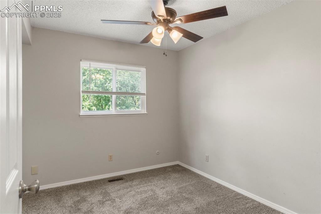 Image 16 of 24: Unfurnished room with carpet flooring, a textured ceiling, and ceiling fan