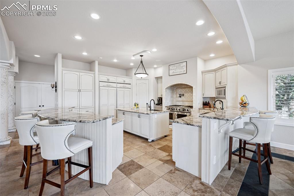 Image 15 of 50: Kitchen with a kitchen island with sink, stainless steel appliances, a kitc