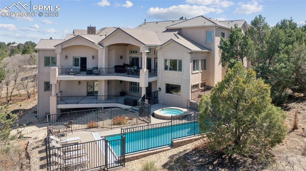 Image 4 of 50: Rear view of house with stucco siding, a patio area, a balcony, and an in g