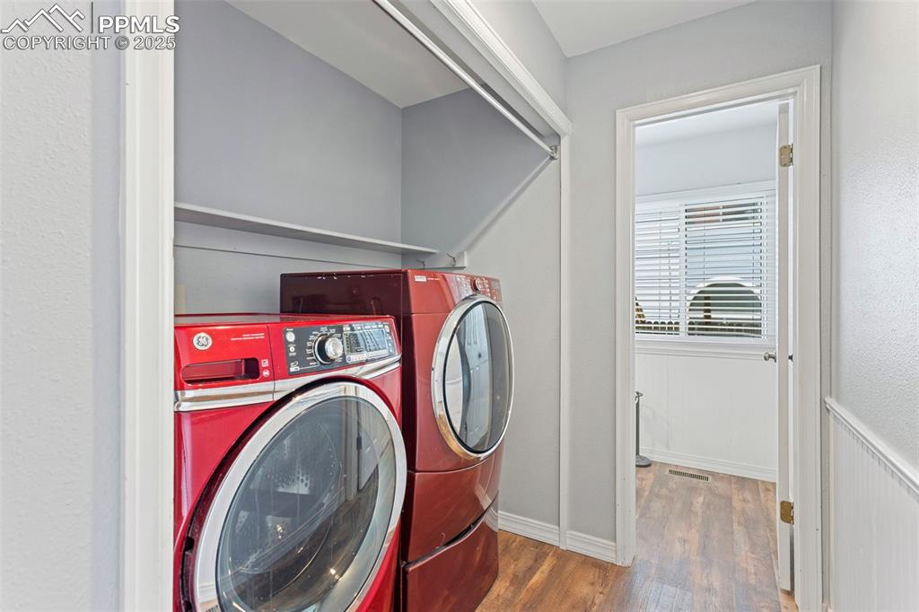 Image 19 of 37: Washroom with wood finished floors and separate washer and dryer