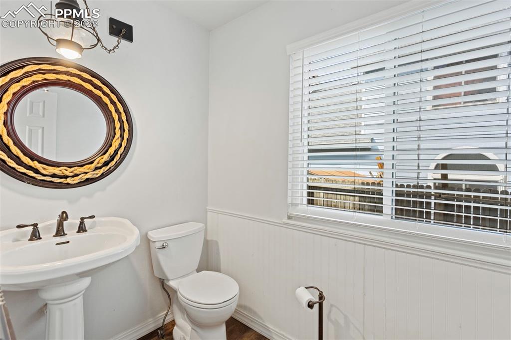 Image 20 of 37: Half bathroom featuring a wainscoted wall and wood walls