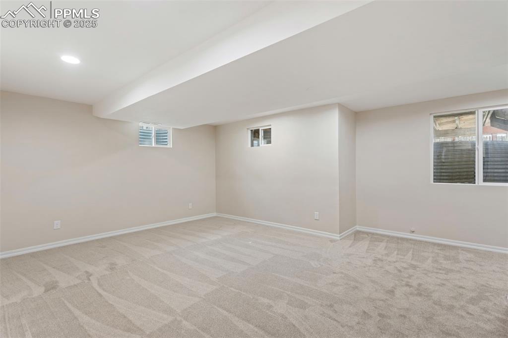Image 30 of 37: Below grade area featuring light carpet and baseboards