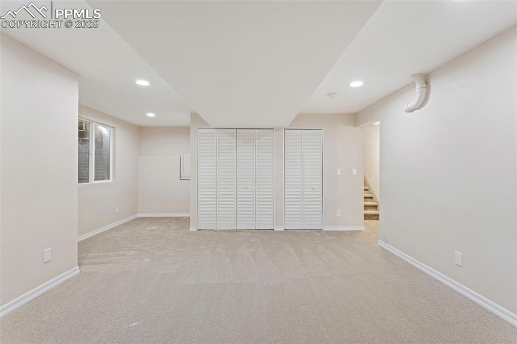 Image 31 of 37: Finished basement featuring light carpet, recessed lighting, and stairs
