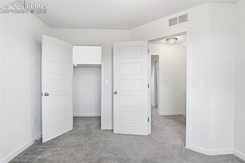 Image 18 of 29: Unfurnished bedroom featuring light carpet and a closet
