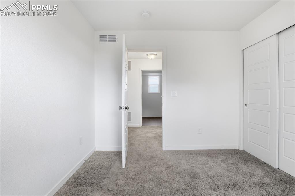 Image 22 of 29: Unfurnished bedroom with light colored carpet and a closet