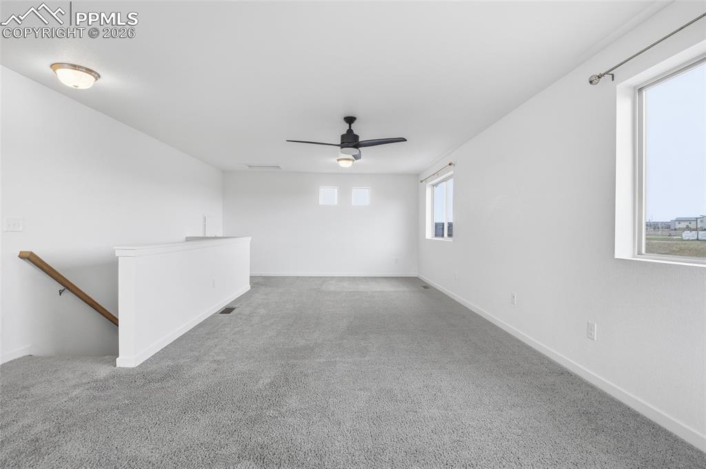 Image 23 of 29: Empty room with carpet floors and a ceiling fan