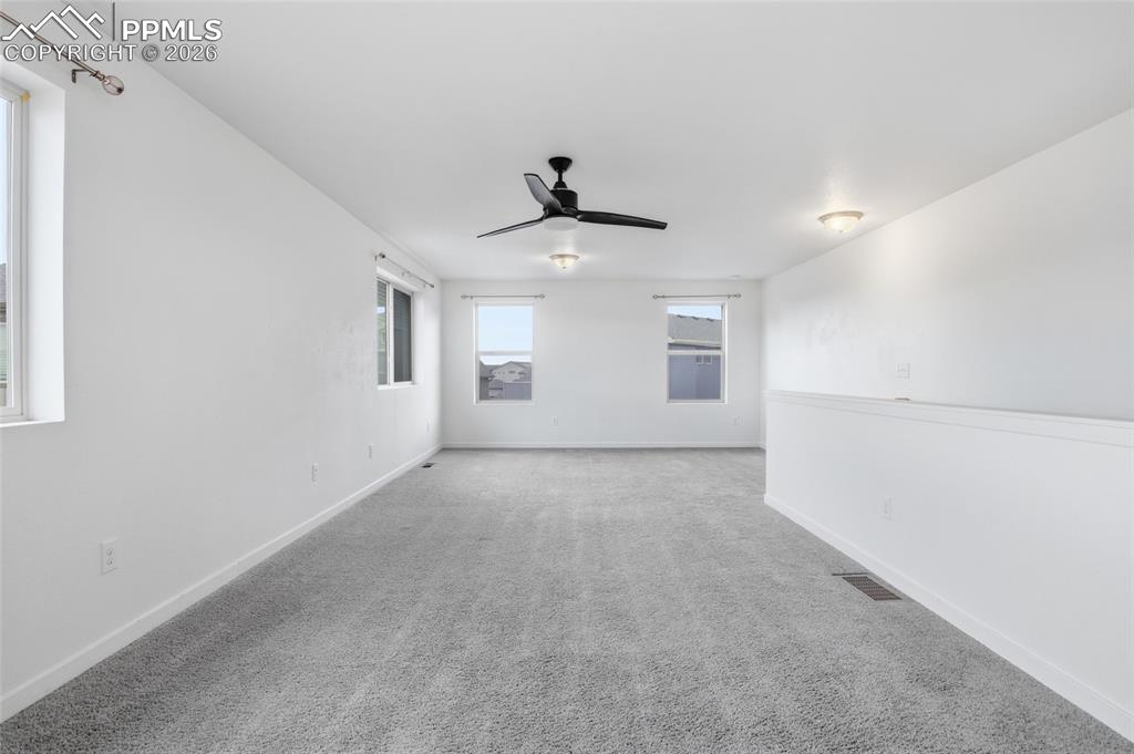 Image 24 of 29: Unfurnished room featuring light carpet and ceiling fan