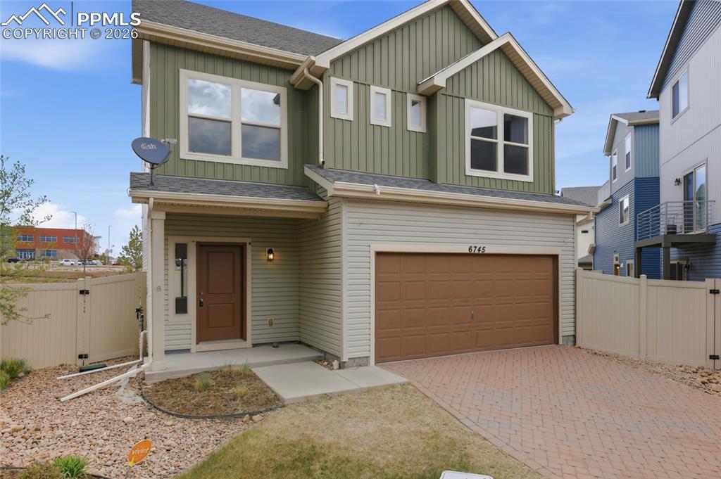 Image 6 of 29: View of front facade with board and batten siding, a gate, a shingled roof,