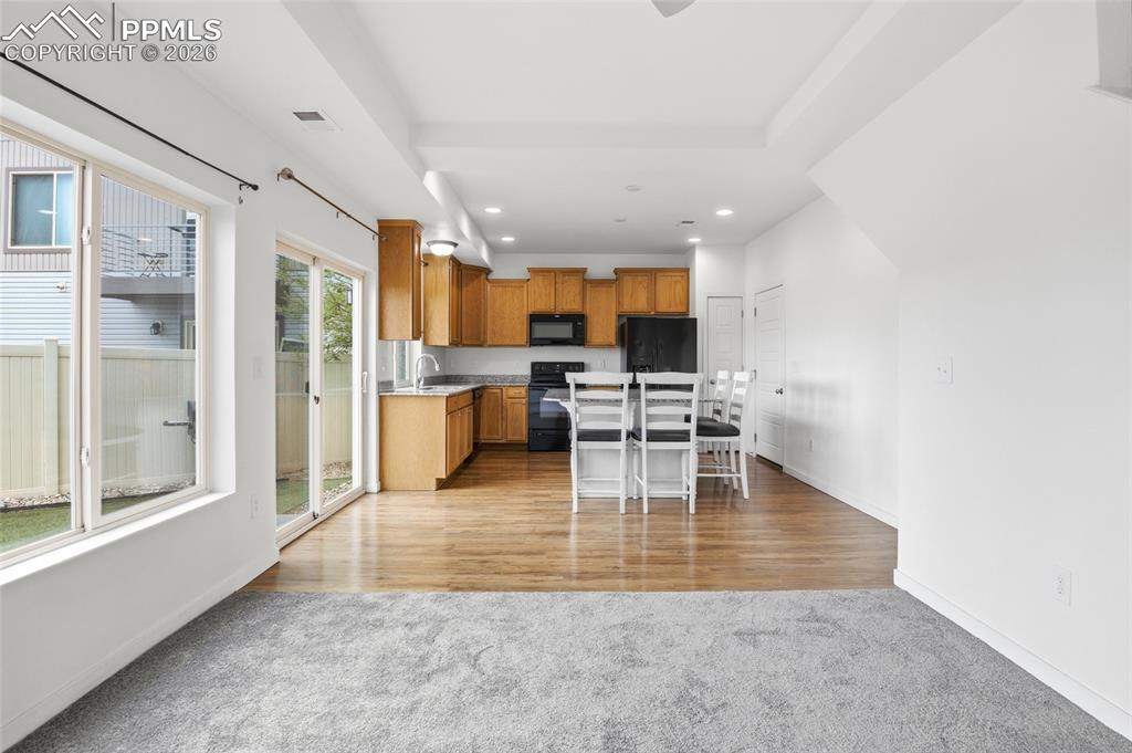 Image 8 of 29: Kitchen featuring a kitchen breakfast bar, black appliances, wood finish ca
