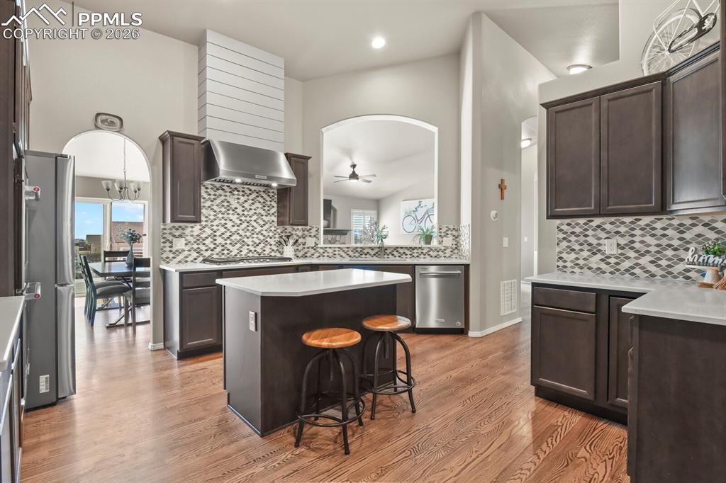 Image 17 of 49: The kitchen features quartz countertops, double oven, gas range with hood v