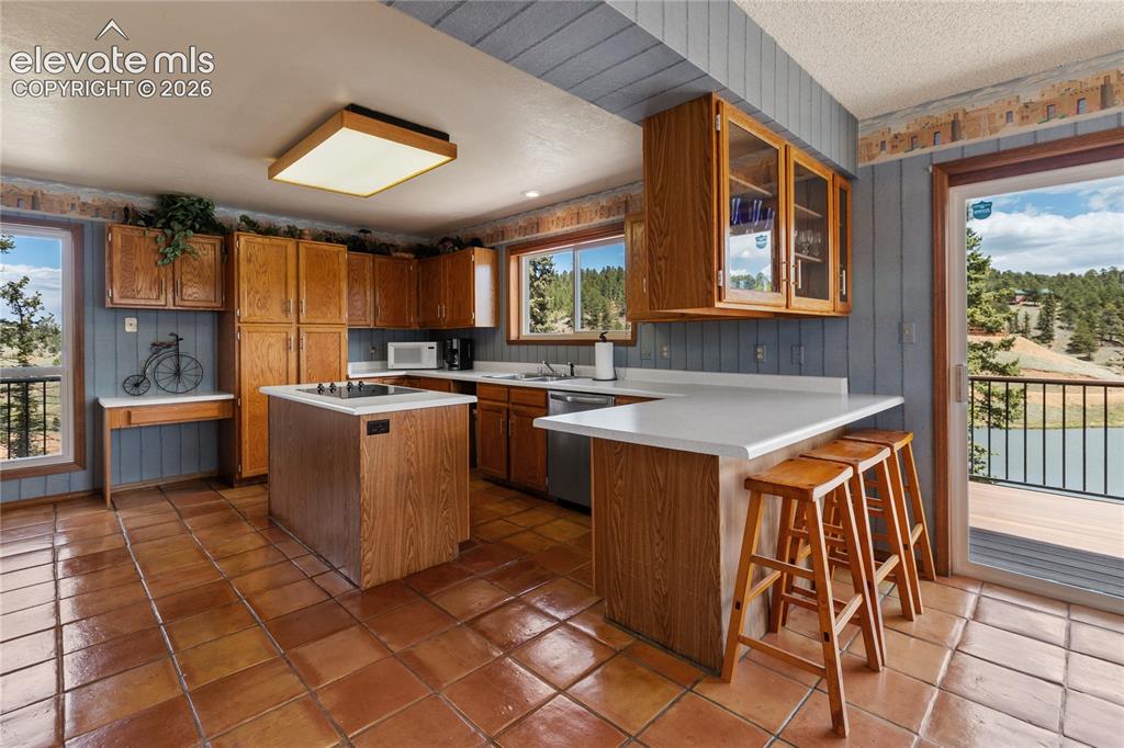 Image 10 of 26: Layout in the kitchen with newer appliances, breakfast bar, and a walk out