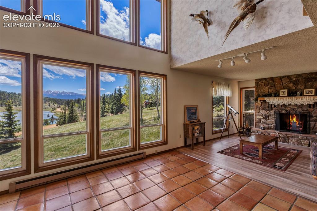 Image 8 of 26: Floor to ceiling windows, a cozy fireplace, lots of character and Saltillo