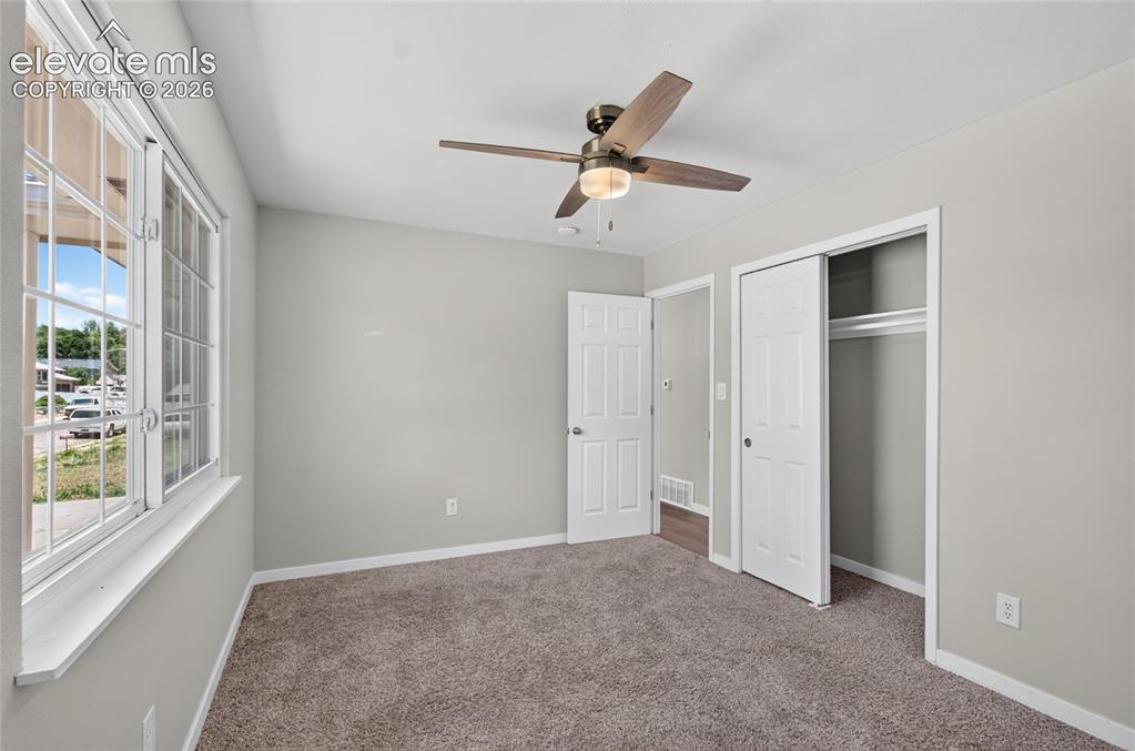 Image 10 of 21: Bedroom featuring textured carpet flooring, light gray wall paint, and a mu