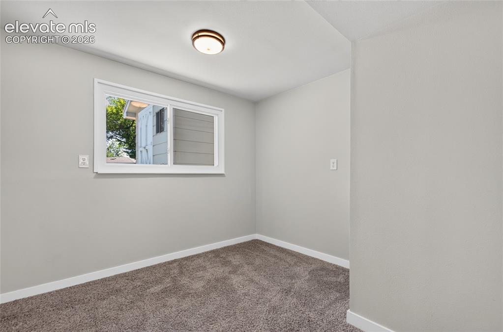 Image 11 of 21: Room featuring light gray painted walls, white baseboards, and brown carpet