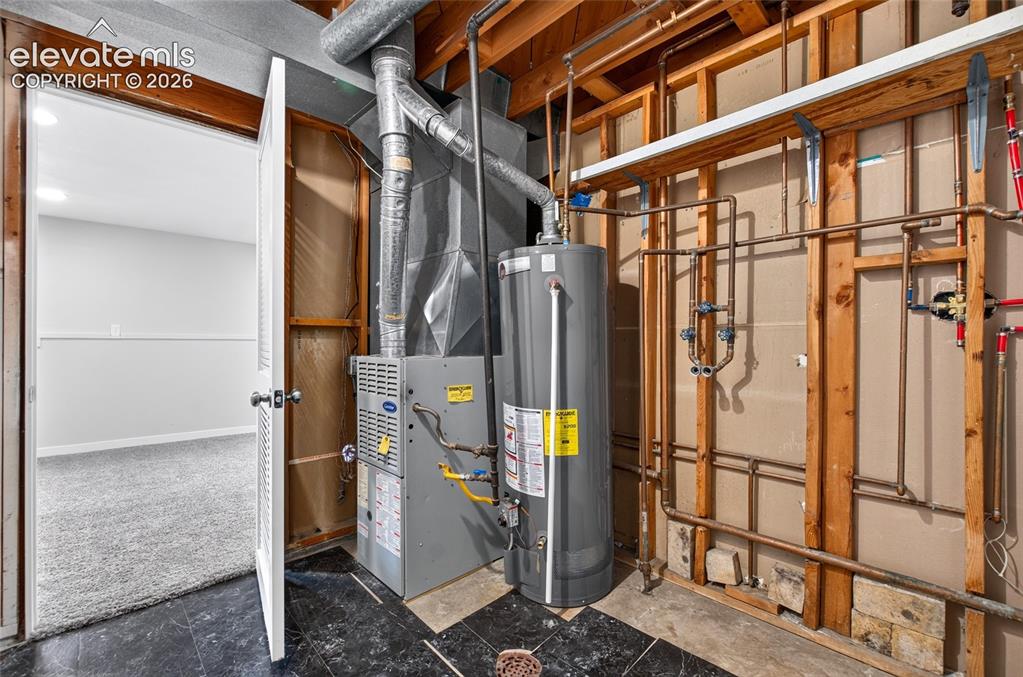 Image 17 of 21: Utility area with a water heater, furnace, exposed copper piping, and ductw
