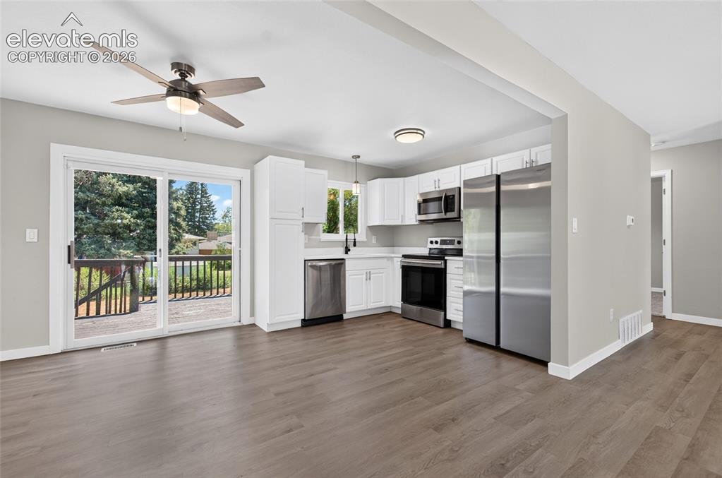 Image 6 of 21: Open-concept living space featuring wood-finish flooring, a ceiling fan wit