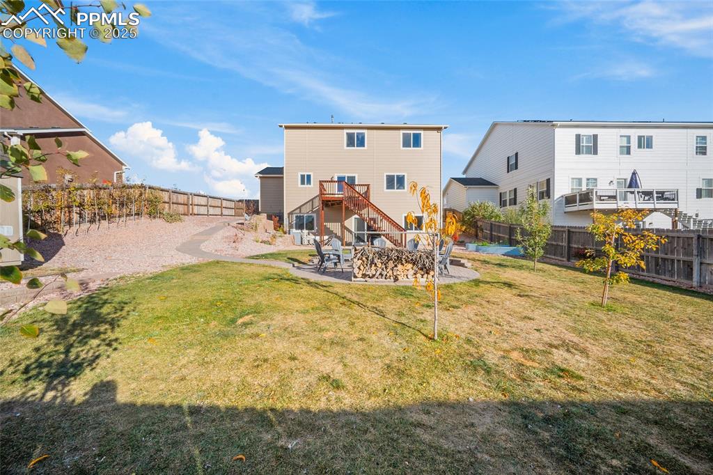 Image 47 of 50: Fire pit in the middle of the yard. New trees recently planted.