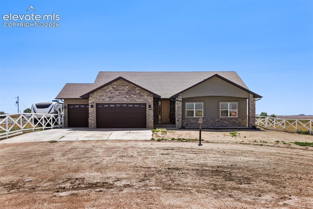 Caption: Ranch-style residence featuring a stone veneer facade, a two-car garage with carriage-style doors, a
