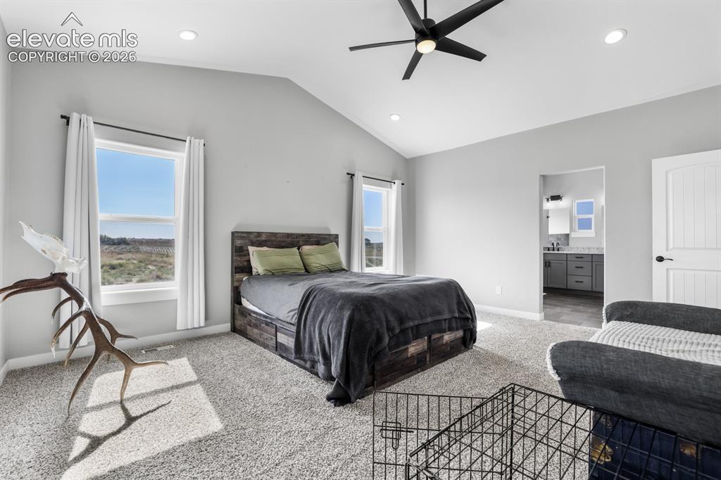 Image 14 of 50: Vaulted ceiling bedroom with recessed lighting, ceiling fan, and two large 
