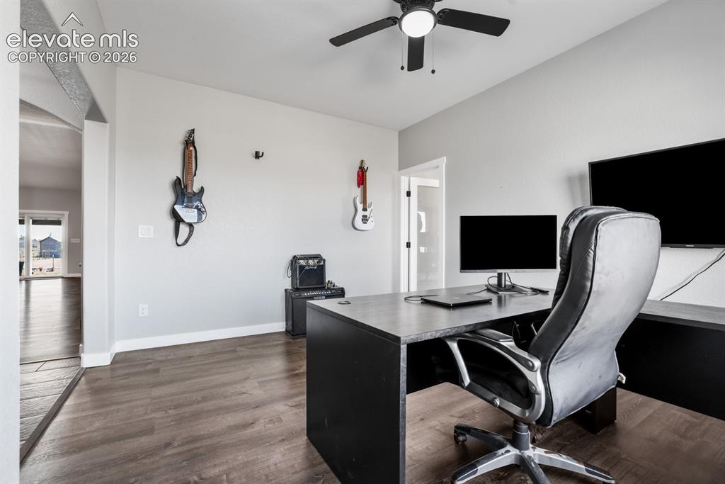 Image 21 of 50: Dedicated workspace featuring wood-finish flooring, light gray walls, and a