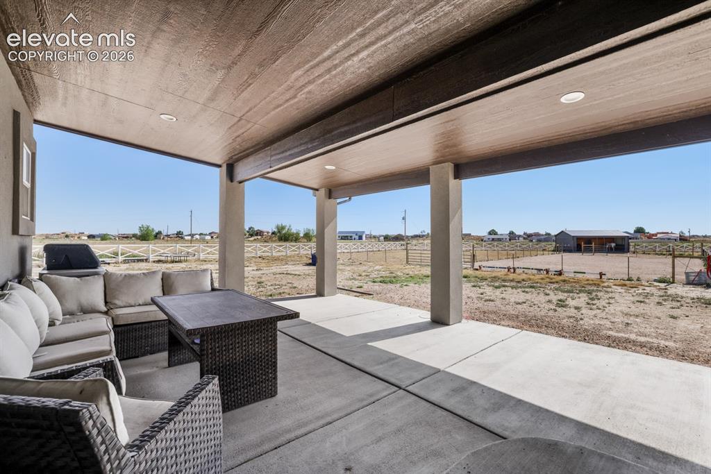 Image 35 of 50: Spacious covered patio with concrete flooring, recessed lighting, and struc