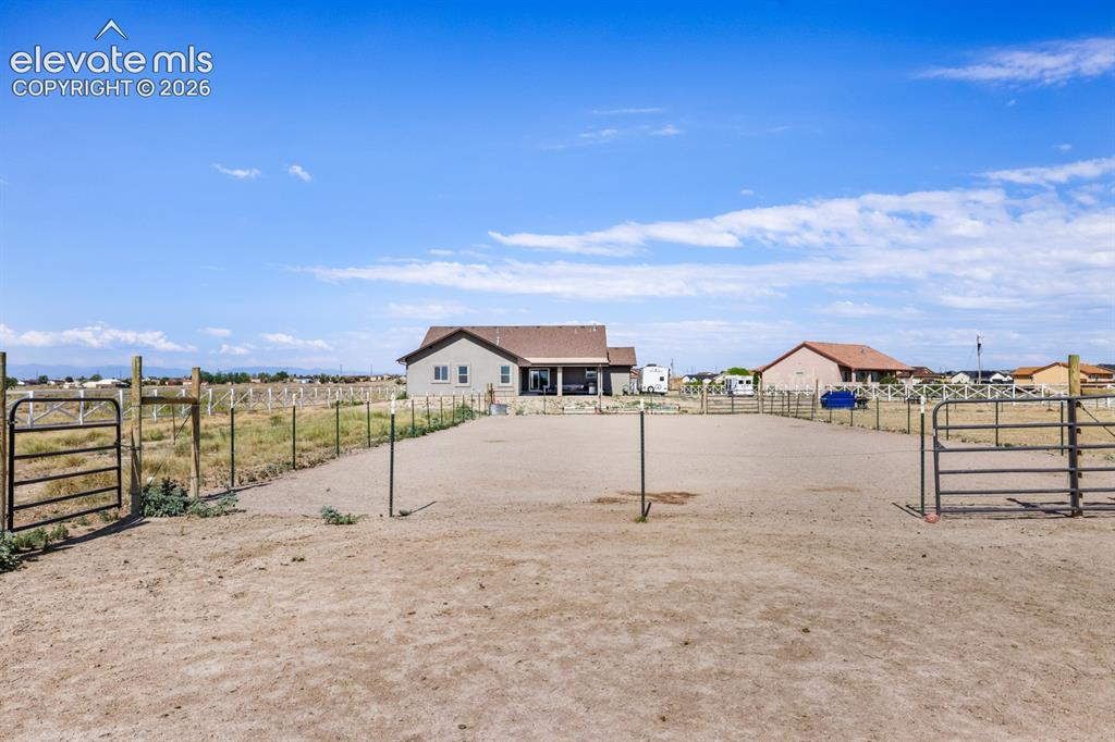 Image 47 of 50: Expansive cleared lot featuring perimeter fencing, multiple metal gates, an