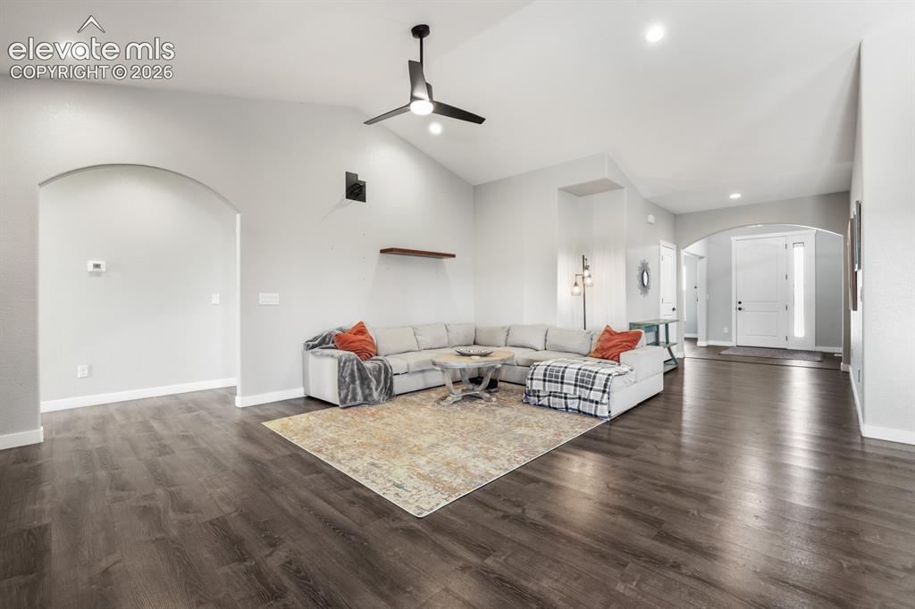 Image 5 of 50: Spacious living area featuring wood-finish flooring, vaulted ceilings, and