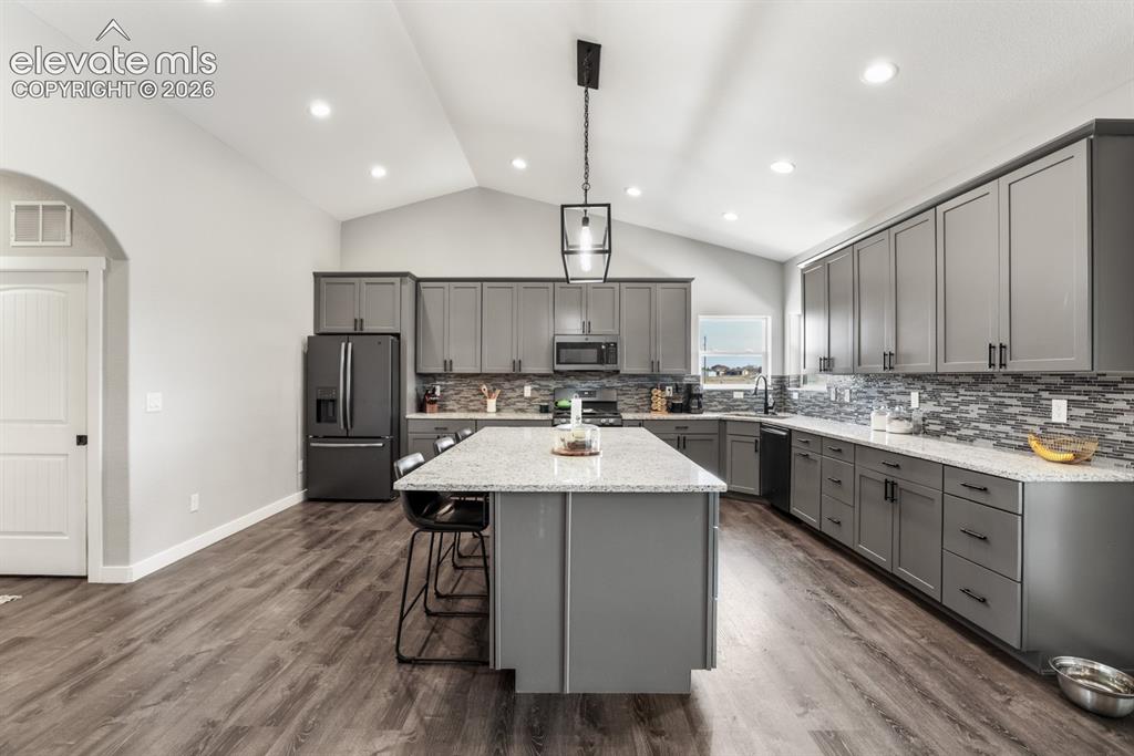 Image 8 of 50: Open-concept kitchen featuring an expansive center island with seating, gre