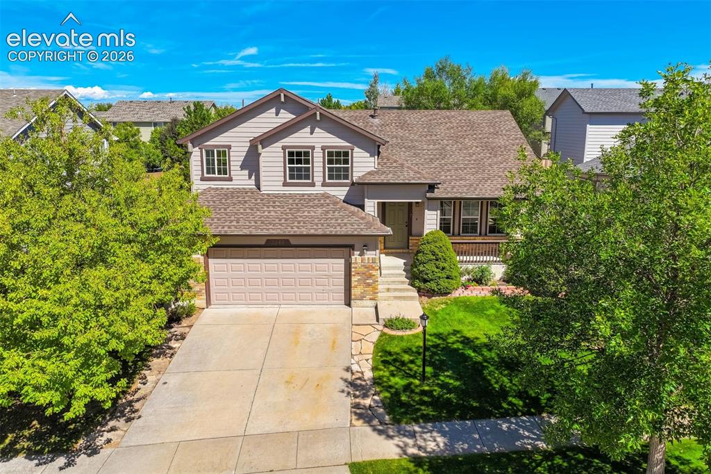 Image 1 of 50: Two-story residence featuring a shingle roof, attached garage, and a covere
