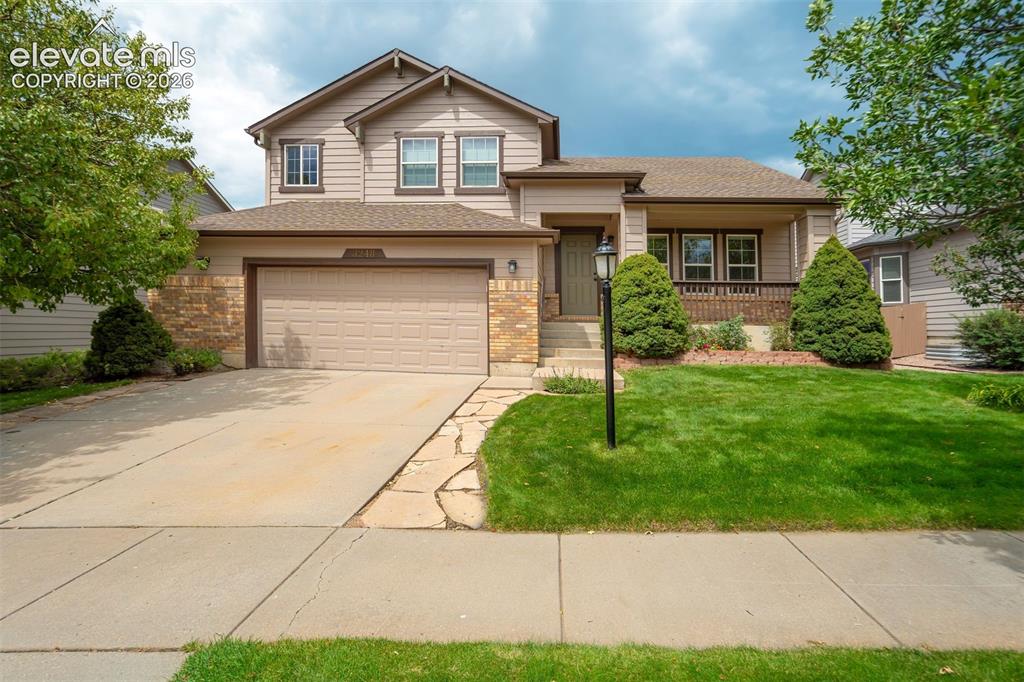 Image 2 of 50: Two-story residence featuring a covered front porch, integrated two-car gar