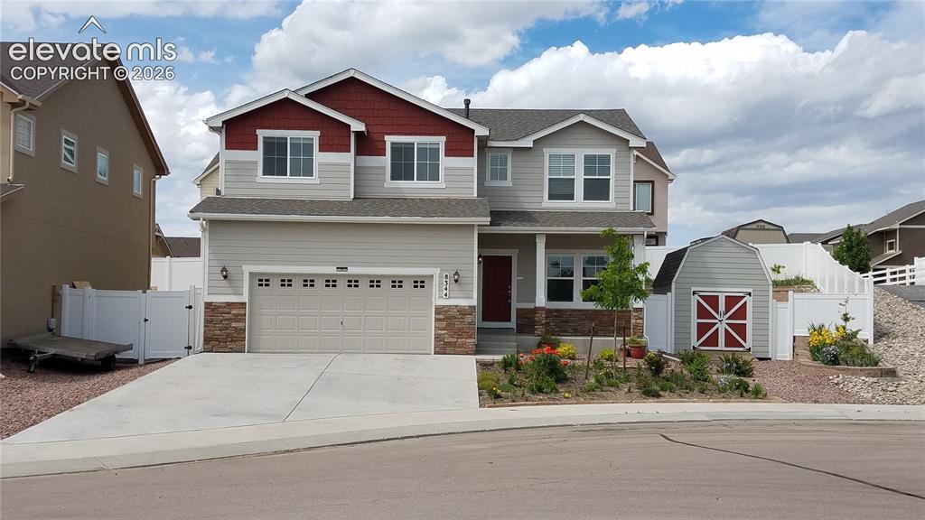 Image 1 of 32: Two-story residence featuring a combination of siding and stone veneer, a t