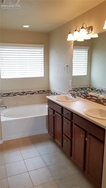 Image 16 of 32: Bathroom featuring a double vanity with wood-finish cabinetry, dual undermo
