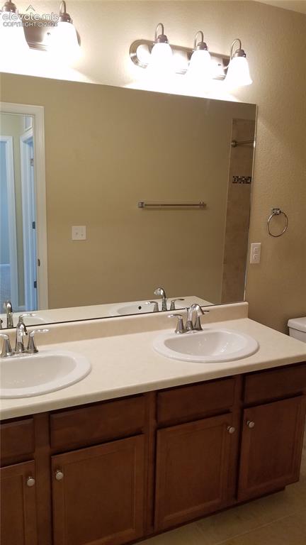 Image 20 of 32: Spacious vanity featuring dual undermount sinks with chrome faucets, a ligh