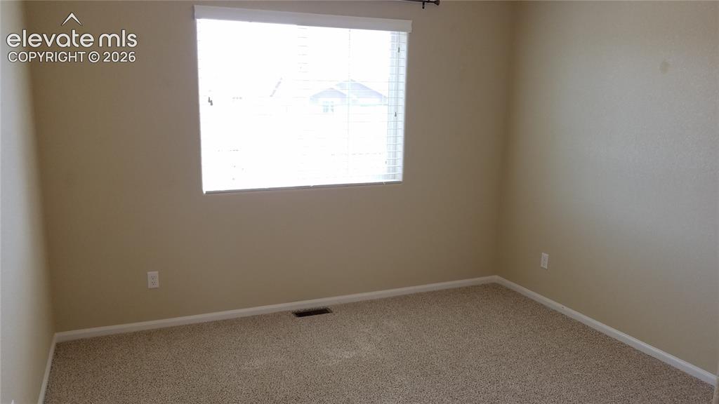 Image 22 of 32: Carpeted room with neutral tone walls