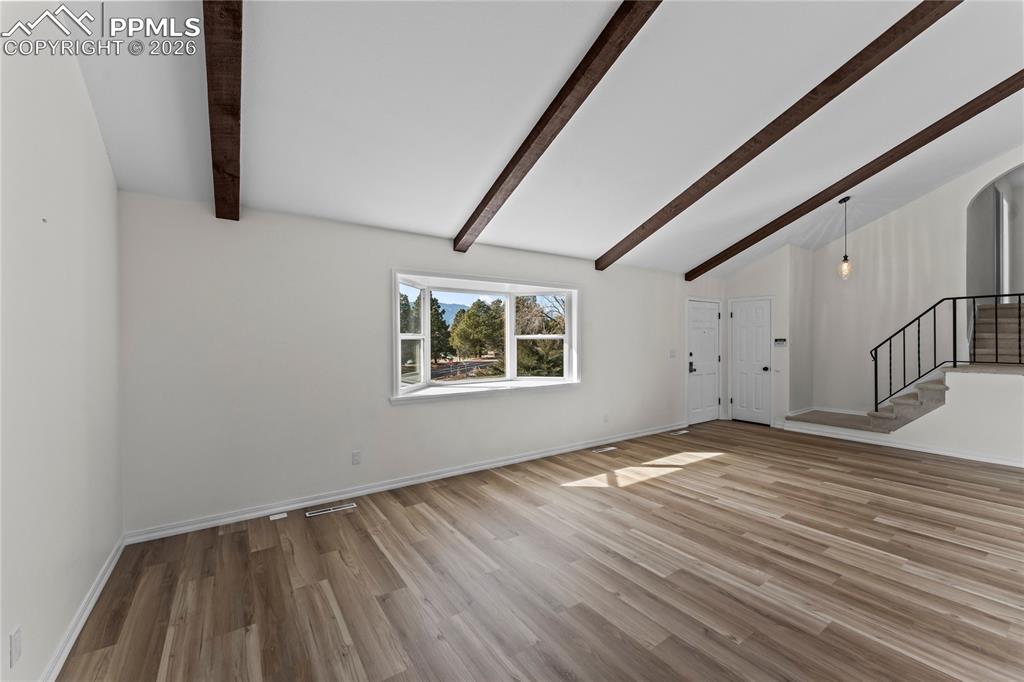 Image 6 of 47: Living room w/ vaulted ceilings & real wood beams