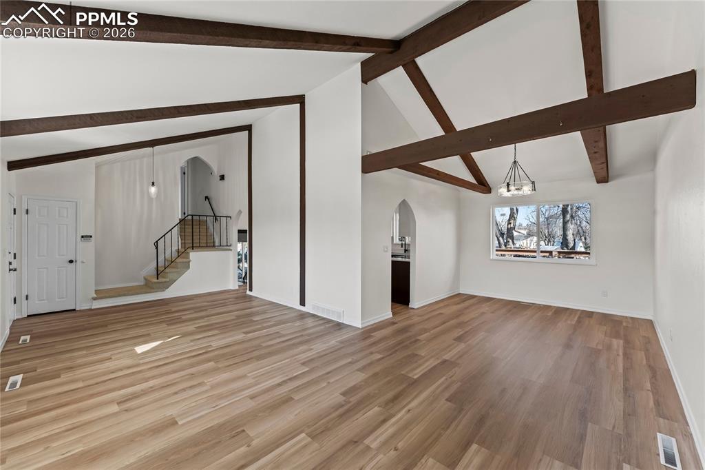 Image 7 of 47: Living room w/ vaulted ceilings & real wood beams