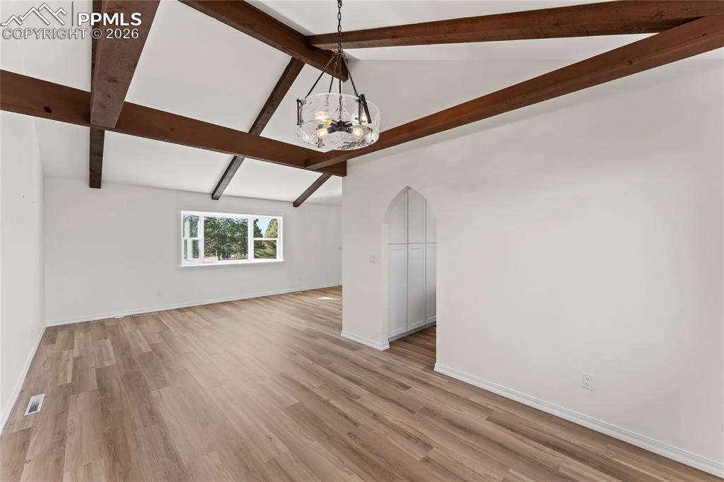 Image 9 of 47: Formal dining room w/wood beams & glass chandelier