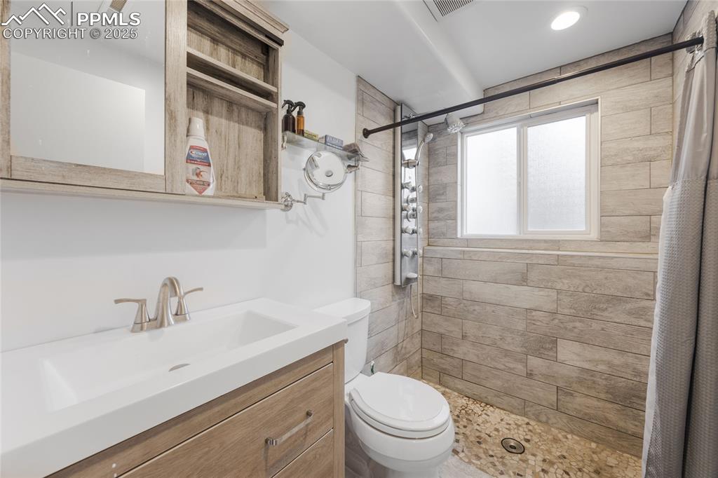 Image 11 of 15: Full bathroom with a stall shower and vanity