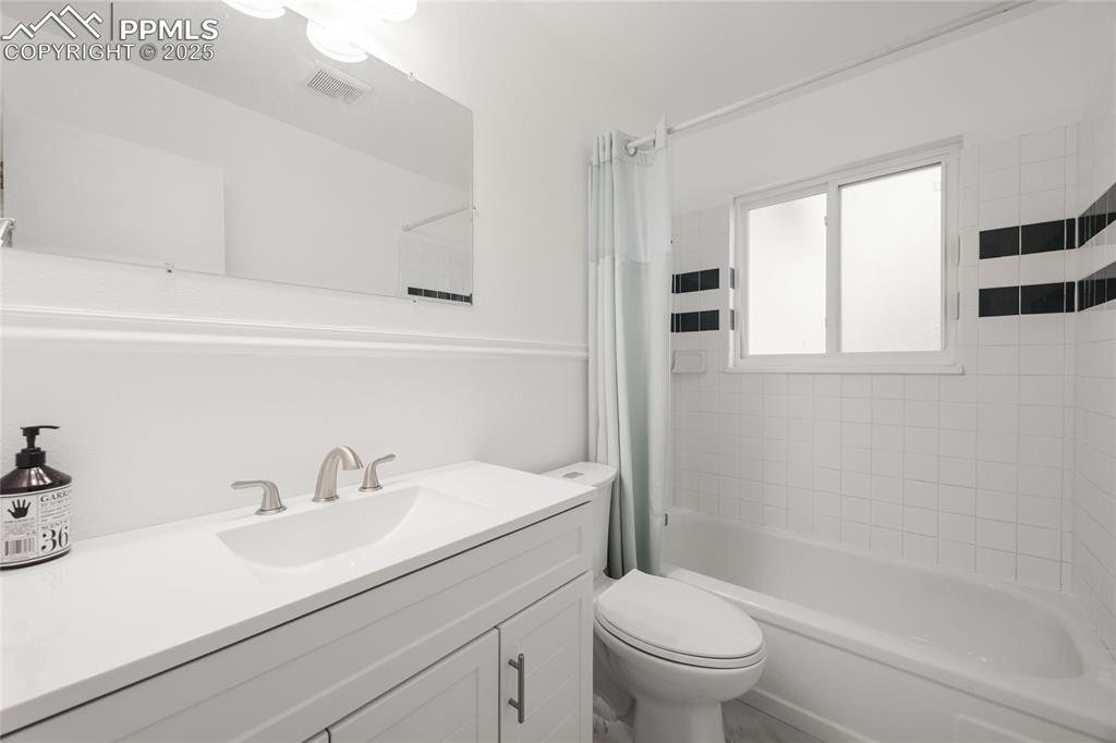 Image 14 of 15: Full bathroom with shower / tub combo and vanity